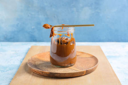 Jar of boiled condensed milk on color backgroundの写真素材