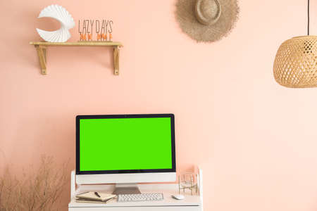 Modern computer with blank screen at workplace in interior of roomの写真素材