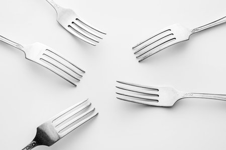 Stylish forks on light background
