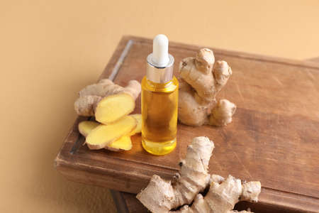 Bottle with ginger essential oil on color backgroundの写真素材