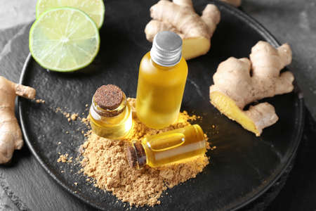 Bottles with ginger essential oil on dark tableの写真素材