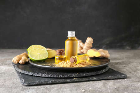 Bottles with ginger essential oil on dark tableの写真素材