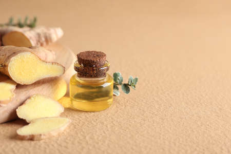 Bottle with ginger essential oil on color backgroundの写真素材