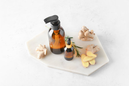 Bottles with ginger essential oil on light backgroundの写真素材