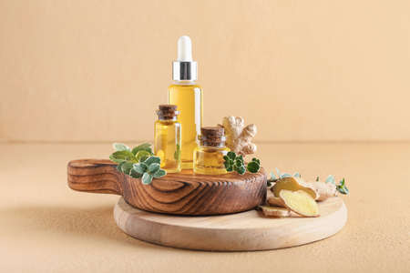 Bottles with ginger essential oil on color backgroundの写真素材