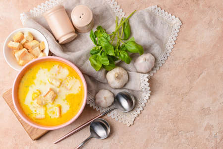 Bowl with tasty garlic cream soup on color backgroundの写真素材