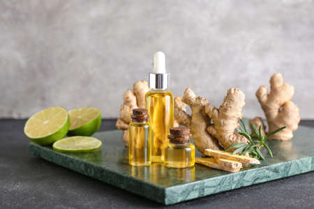 Bottles with ginger essential oil on dark background