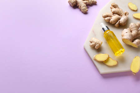 Bottle with ginger essential oil on color backgroundの写真素材