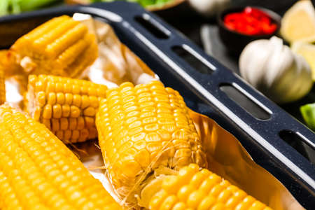 Baking dish with tasty baked corn cobs, closeupの写真素材