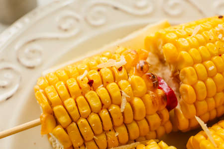 Plate with tasty baked corn cobs on light background, closeupの写真素材
