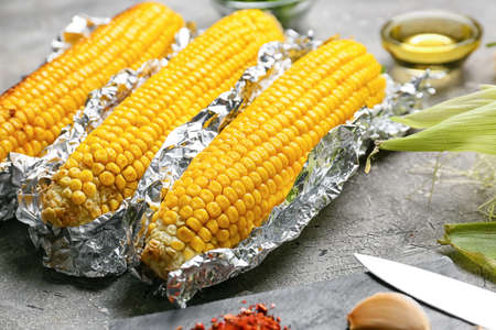 Tasty baked corn cobs on gray backgroundの写真素材