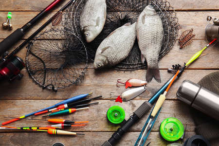 Different fishing equipment and fish on wooden backgroundの写真素材