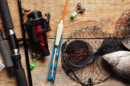 Different fishing equipment and fish on wooden backgroundの写真素材