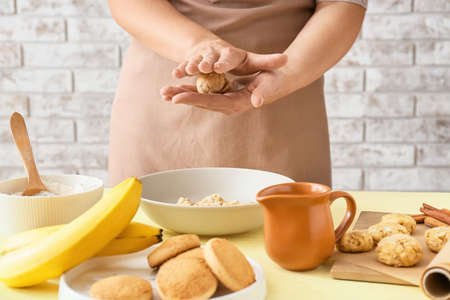 Woman preparing banana cookies in kitchenの写真素材