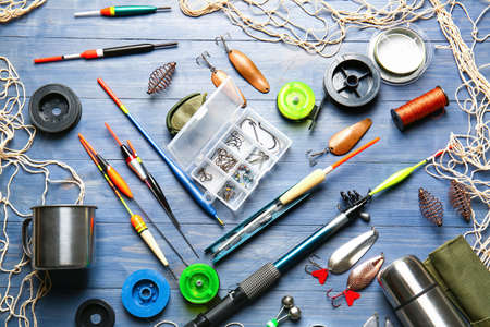 Different fishing equipment on color wooden backgroundの写真素材