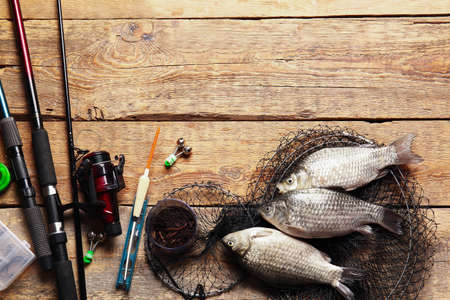 Different fishing equipment and fish on wooden backgroundの写真素材
