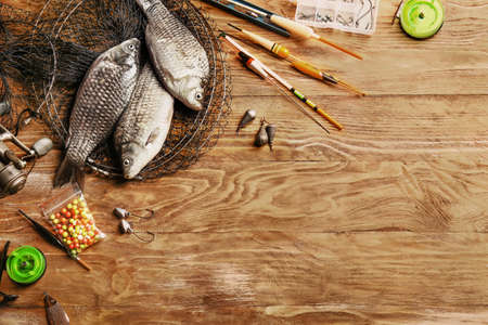 Different fishing equipment and fish on wooden backgroundの写真素材