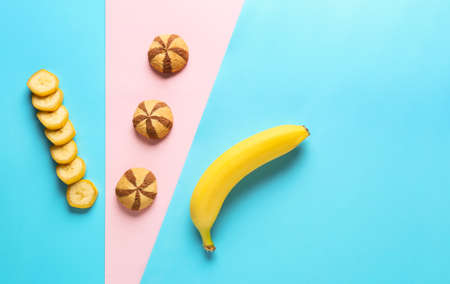 Creative composition with tasty cookies and banana on color backgroundの写真素材