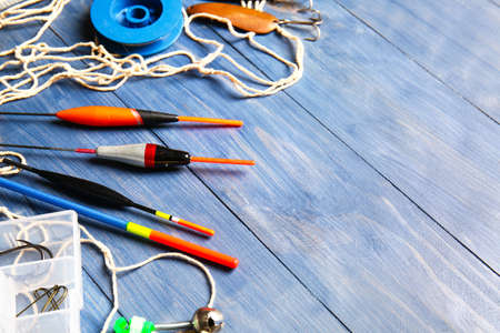 Different fishing equipment on color wooden background