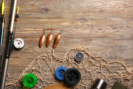 Different fishing equipment on wooden background