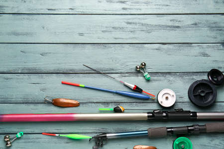 Different fishing equipment on color wooden background