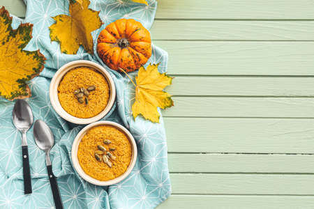 Autumn composition with tasty pumpkin pudding on color wooden background