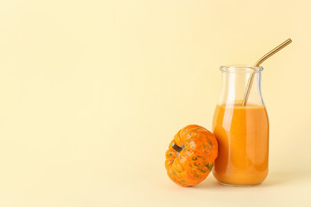 Bottle of tasty pumpkin smoothie on color backgroundの写真素材