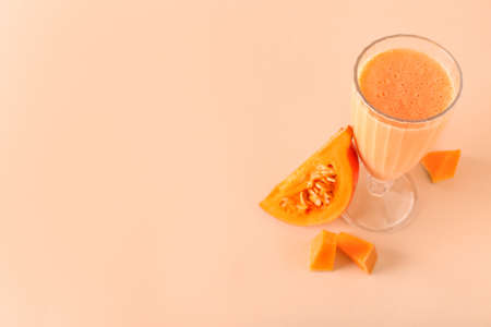 Glass of tasty pumpkin smoothie on color backgroundの写真素材