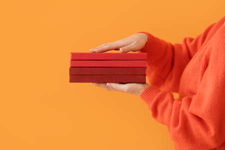 Woman with books on color background