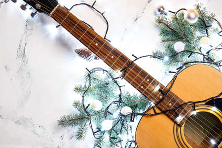 Guitar with Christmas lights and decor on light backgroundの写真素材