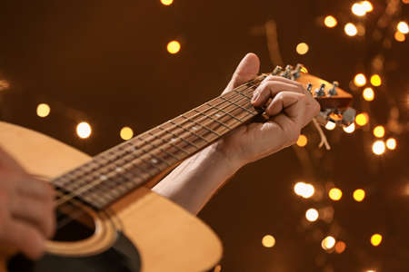 Man playing guitar on Christmas eve, closeup