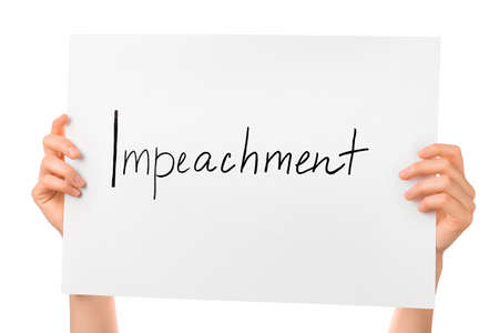 Hands holding paper with text IMPEACHMENT on white background