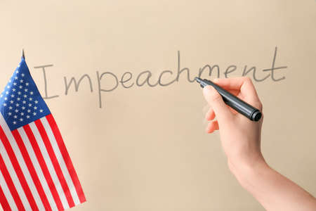 USA flag and hand writing text IMPEACHMENT on color backgroundの写真素材