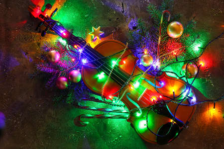 Violin with Christmas lights and decor on dark background