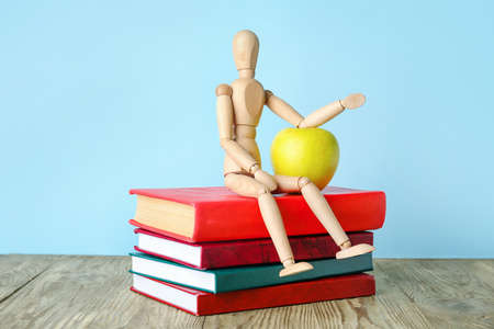 Wooden mannequin on color background. Concept of studyingの写真素材