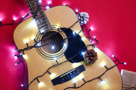 Guitar with Christmas lights on color backgroundの写真素材