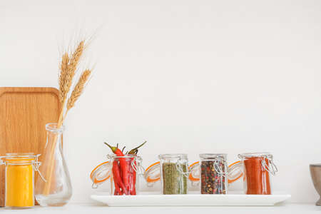 Jars with different spices on shelf in kitchenの写真素材