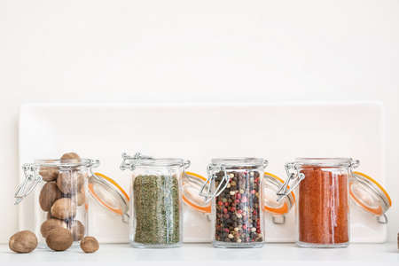 Jars with different spices on shelf in kitchenの写真素材