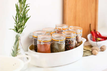 Jars with different spices on table in kitchenの写真素材