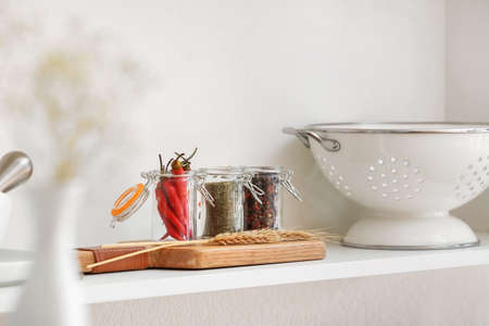 Jars with different spices on shelf in kitchenの写真素材