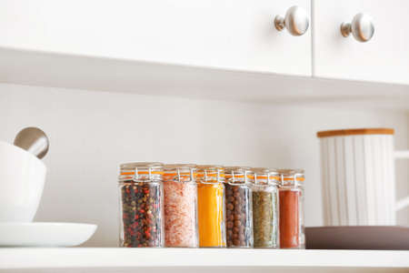 Jars with different spices on shelf in kitchenの写真素材