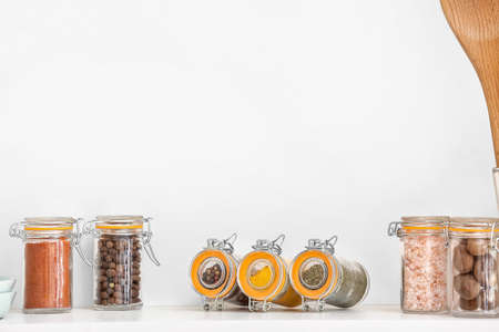 Jars with different spices on table in kitchenの写真素材