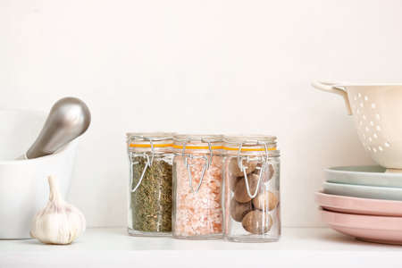 Jars with different spices on table in kitchenの写真素材