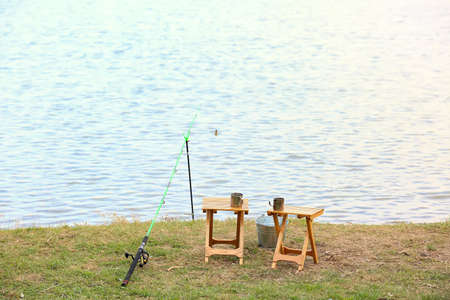 Fishing rod, bucket and stools on river bankの写真素材