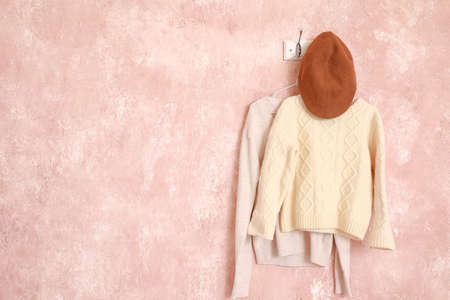 Hanger with stylish clothes on color backgroundの写真素材