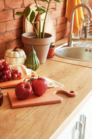 Board with ripe apples on kitchen table