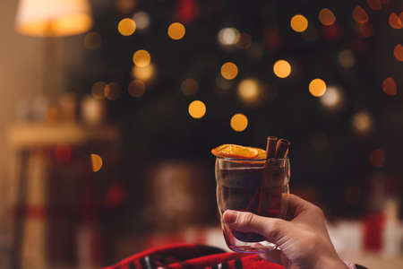 Woman with tasty mulled wine at home on Christmas eveの写真素材