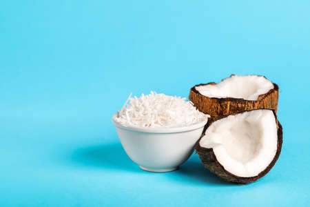 Bowl with coconut flakes on color backgroundの写真素材