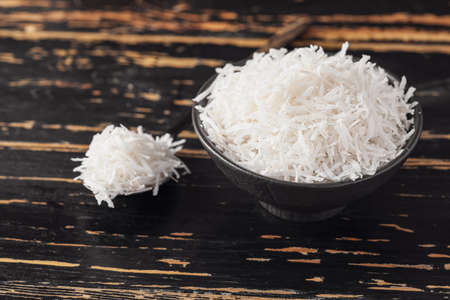 Bowl with coconut flakes on wooden backgroundの写真素材