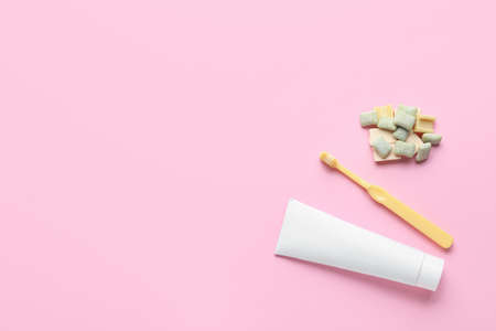 Chewing gums, toothbrush and paste on color backgroundの写真素材